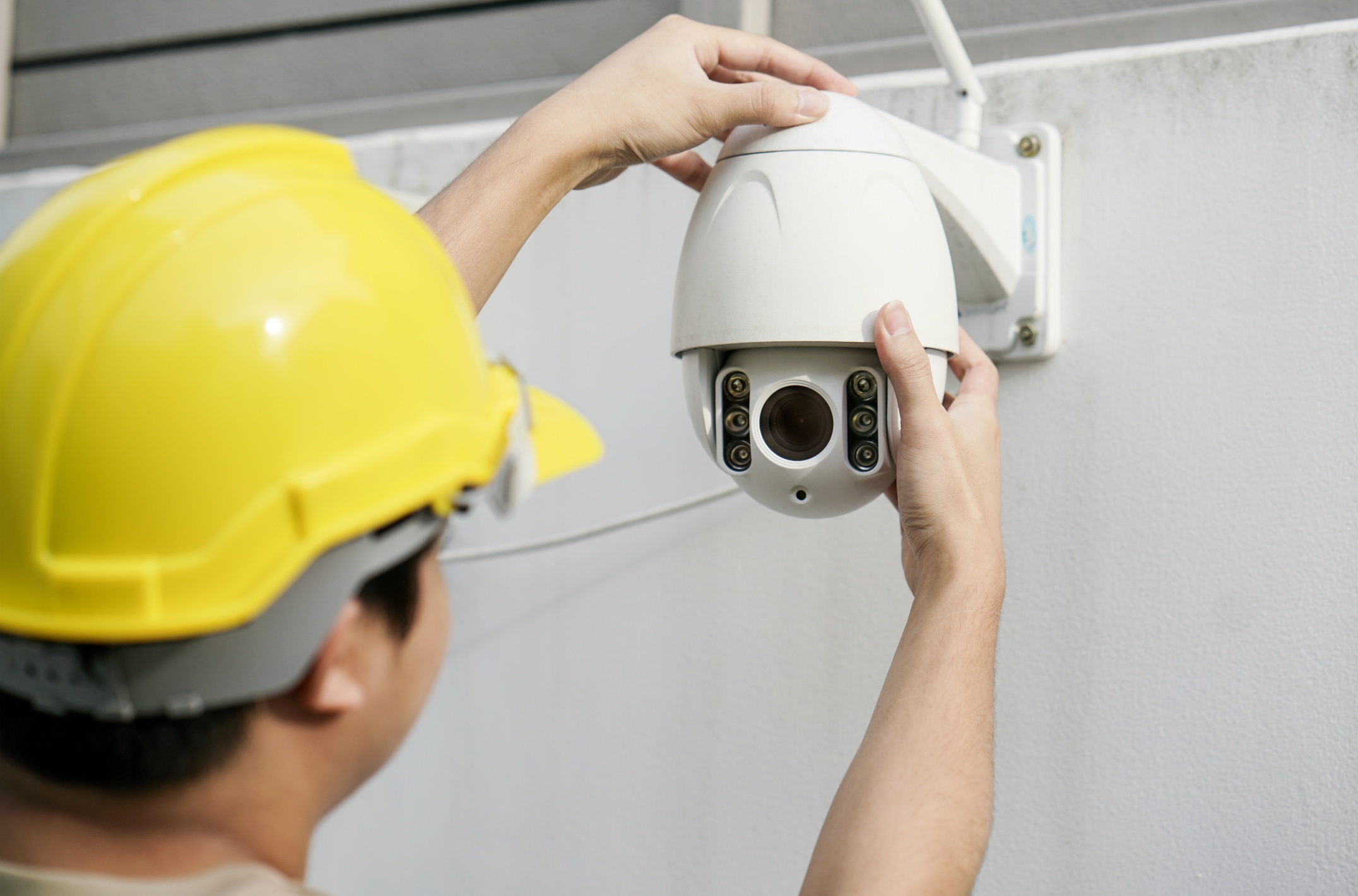 close-up-male-technician-fixing-cctv-camera-wall